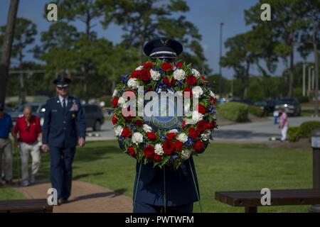Ein Mitglied der Hurlburt Field Ehrengarde trägt einen Kranz an der Operation Eagle Claw Gedenkveranstaltung in Hurlburt Field, Fla., 23. Juni 2017. Operation Eagle Claw war eine versuchte Geiselnahme Rescue Mission im Jahre 1980, dass in fünf 8 Special Operations Squadron Flieger und drei Marines ihr Leben zu opfern, wenn zwei der beteiligten Flugzeuge in der Wüste ein Staging Site kollidierte geführt. Stockfoto
