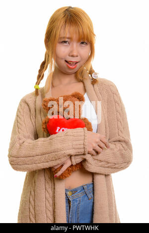 Junge asiatische Frau glücklich lächelnd und umarmen Teddybär mit hören Stockfoto