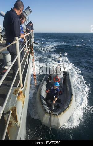 Arabischen Golf (20. Juni 2017) eine starre - Rumpf Schlauchboot von der Küstenwache Schiff USS Feuerblitz (PC10) zieht neben den geführten-missile Cruiser USS Vella Golf (CG72) für ein Personal transfer während der Übung Spartan Kopis 17, Juni 20. Übung Spartan Kopis ist eine Task Force (TF) 55 - LED-Übung zwischen der US Navy und der US-Küstenwache, um taktische Kenntnisse verbessern, erweitern und Ebenen der Zusammenarbeit, gegenseitige Unterstützung und langfristige Sicherheit und Stabilität in der Region erhöhen. Vella Golf ist in den USA der 5 Bereich der Flotte im Einsatz sind Verbündete und Partne zu beruhigen Stockfoto