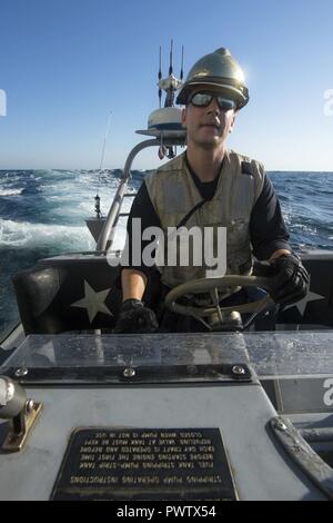 Arabischen Golf (20. Juni 2017) Leutnant James Clendenin, zugeordnet zu den Coastal Patrol Schiff USS Feuerblitz (PC 10), steuert eine starre - Rumpf aufblasbares Boot wie es zieht neben den geführten-missile Cruiser USS Vella Golf (CG72) Personal während der Übung Spartan Kopis 17 zu übertragen. Übung Spartan Kopis ist eine Task Force (TF) 55 - LED-Übung zwischen der US Navy und der US-Küstenwache, um taktische Kenntnisse verbessern, erweitern und Ebenen der Zusammenarbeit, gegenseitige Unterstützung und langfristige Sicherheit und Stabilität in der Region erhöhen. Vella Golf ist in den USA der 5 Bereich der Flotte im Einsatz Stockfoto