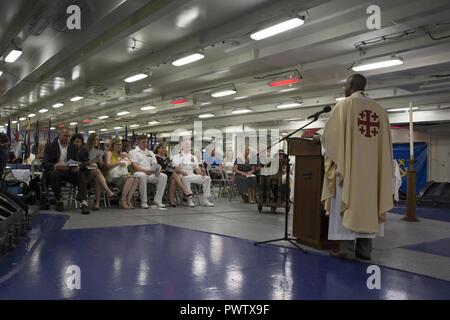 NORFOLK, Virginia (24. Juni 2017) - - Leutnant John 'Jack' Curran, zugeordnet zu den Pre-Commissioning Unit Gerald R. Ford (CVN 78), und seine Frau, Lt Emily Curran, einem Flugzeugträger Neubau Assistant Project Officer für Supervisor des Schiffbaus, ihr Sohn taufen während einer Zeremonie in der Schiff-back. Der Brauch der tauft Säuglinge an Bord von Schiffen der britischen Royal Navy, in der die Kinder unter oder im Inneren des Schiffes Bell getauft ist. ( Stockfoto