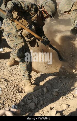 TWENTYNINE PALMS, Kalifornien - ein Marine mit Oscar Batterie, 5 Bataillon, 14 Marine Regiment, Marine Reserve, gräbt ein Loch groß genug für den Spaten eines M777 Haubitze im Marine Corps Air Ground Combat Center Twentynine Palms, Kalifornien, 22. Juni 2017 während der integrierte Ausbildung Übung 4-17 zu passen. ITX war der größte US Marine Corps finden Training Übung im Jahr 2017, mit Marines und Segler aus über 20 Einheiten und 15 Staaten teilnehmen. Stockfoto