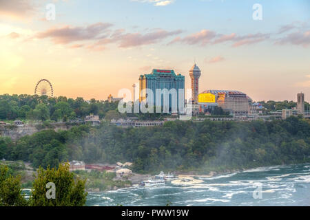 NIAGARA FALLS, USA - 26.August 2012: Golden Sunset über der kanadischen Seite der Niagarafälle an der Grenze zu Kanada und die USA in der Nähe der Rainbow Bridge, mit Nebel steigt Stockfoto