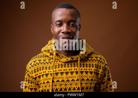 Studio shot junger afrikanischer Menschen gegen den braunen Hintergrund Stockfoto