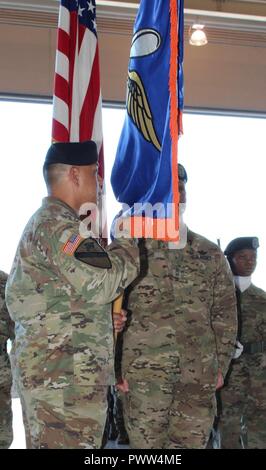 Eingehende U.S. Army Alaska Aviation Task Force Commander Col. Glen Heape hält die Task Force die Farben für die erste Zeit nach dem Akzeptieren sie und die Führung der "Arctic Falken" aus USARAK Commander Generalmajor Bryan Owens während der UATF Ändern des Befehls Juni 29 am Fort Wainwright, Alaska. Stockfoto