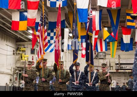CORAL SEA (29. Juni 2017) Matrosen und Marines stehen Seite an Seite mit dem offiziellen Color Guard für den Talisman Sabre Eröffnungsfeier 2017 auf der Amphibisches Schiff USS BONHOMME RICHARD (LHD6). Talisman Säbel ist eine Biennale USA - Australien bilaterale militärische Übung, verbindet ein Feld Training und Kommandostellenübung Interoperabilität und zur Stärkung der Grundsätze der amerikanisch-australische Bündnis zu wahren. Stockfoto