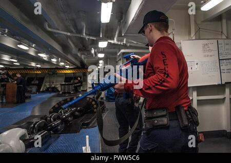 WESTERN PACIFIC (27. Juni 2017) Master-at-Arms Seaman Kelson Meilen, von Madison, Wisconsin, demonstriert - clearing Techniken an Bord der Marine vorwärts - bereitgestellt Flugzeugträger USS Ronald Reagan (CVN 76), während eine integrierte Ausbildung Bohrer mit Ship Security Force und die Beseitigung von Explosivstoffen (EOD) Personal. Der Bohrer wurde entwickelt, um die Fähigkeit der Reagan Sicherheitskräfte und EOD-Teams, zusammen zu arbeiten, die bei einer Sicherheitsverletzung zu verteidigen zu testen. Ronald Reagan, das Flaggschiff der Carrier Strike Group 5, bietet eine Bekämpfung bereit, Kraft, schützt und verteidigt die Coll Stockfoto