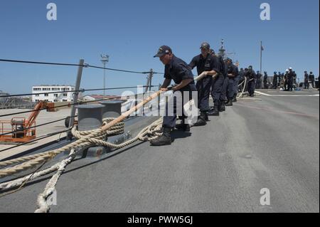 NAVAL STATION Rota, Spanien (26. Juni 2017) - Line Handler, an Bord der Arleigh-Burke-Klasse geführte Anti-raketen-Zerstörer USS Carney (DDG64), hebe eine Linie beim Abflug Naval Station Rota, Spanien, 26. Juni 2017. Carney, Vorwärts - Rota, Spanien bereitgestellt werden, ist die Durchführung der dritten Patrouille in den USA 6 Flotte Bereich der Maßnahmen zur Unterstützung der US-amerikanischen nationalen Sicherheitsinteressen in Europa. ( Stockfoto