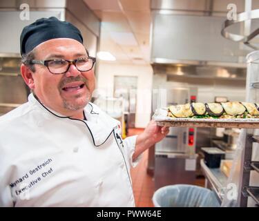 Maynard Oestreich, Executive Chef für Aramark Mahlzeiten bereitet vor der Flieger Führung Schulabschluss bei Travis Air Force Base, Calif., 28. Juni 2017. Oestreich einem ehemaligen US Navy Veteran und einem preisgekrönten Küchenchef aus Napa Valley, Calif., nahm der Küchenchef Position, so dass er Mentor junger Flieger könnte. Stockfoto