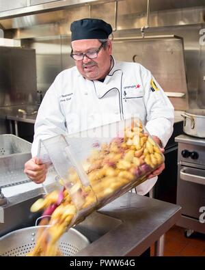 Maynard Oestreich, Executive Chef für Aramark Mahlzeiten bereitet vor der Flieger Führung Schulabschluss bei Travis Air Force Base, Calif., 28. Juni 2017. Oestreich einem ehemaligen US Navy Veteran und einem preisgekrönten Küchenchef aus Napa Valley, Calif., nahm der Küchenchef Position, so dass er Mentor junger Flieger könnte. Stockfoto