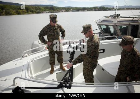 Us Marine Oberst Michael V. Samarov, der Kommandant von Special Purpose Marine Air-Ground Task Force - Southern Command, untersucht ein Maschinengewehr mit US Marine Sgt. Maj. Glenn D. Bragg, der SPMAGTF-SC Sergeant Major und US Marine Kapitän Theodore J. Hardy, der die El Salvador Loslösung, Zusammenarbeit im Bereich der Sicherheit Training Team, SPMAGTF-SC, während an Bord ein Boston Whaler in La Union Naval Base in La Union, El Salvador, 26. Juni 2017. Samarov met mit verschiedenen Elementen seiner Einheit und verschiedenen wichtigen Führungskräften während seiner Zirkulation zu verschiedenen Ländern in Mittelamerika, in denen S Stockfoto