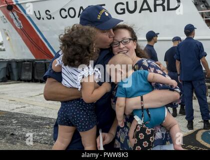 Ein besatzungsmitglied an Bord der Coast Guard Cutter Verwegenen vereint mit seiner Familie am Samstag, 1. Juli 2017, nach seiner Rückkehr nach St. Petersburg, Florida. Der Cutter zurückgekehrt, nach einem 60-tägigen Trainings- und Strafverfolgungsbehörden Patrouille in der Mitte des Atlantischen Ozeans zur Unterstützung der Operation Ocean Hunter. Stockfoto