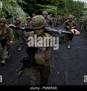 US Marine Corps 2nd Lt. Kirstin Spann, der Adjutant befestigt, Marine Wing Support Squadron (MWSS) 171, Sitz in Marine Corps Air Station Iwakuni, trägt ein M240B Maschinengewehr und ein Gewehr M4 Carbine während der Wanderung zurück zum Ausgangspunkt nach Abschluss der Übung Eagle Zorn 2017 bei kombiniert Arme Training Center Camp Fuji, Japan, 26. Juni 2017. Nach vorne bedienen Basen und vorwärts Bewaffnung und Betankung Punkte entstanden während der zweiwöchigen Übung trainieren die Marines, Sprengstoffe, Waffen, Treibstoff, Sicherheit, Logistik und Personal zu einer Hinleitung der Truppen und Aircr bieten Stockfoto