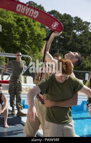 Eine Marine Corps Instructor von Wasser überleben zum 2. Marine Flugzeugflügel zugewiesen wird veranschaulicht, wie ein Opfer im Wasser Survival-Advanced (WSA) Ausbildung bei der Marine Corps Air Station Cherry Point, N.C., 29. Juni 2017 zu retten. WSA ist ein Kurs, der Tests Marines auf Anschläge, Distanz schwimmen, und ihre Fähigkeit, distressed Marines im realen Leben Szenarien zu retten. Stockfoto