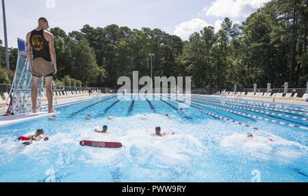 Eine Marine Corps Instructor von Wasser überleben zum 2. Marine Flugzeugflügel zugeordnet Wasserrettung Bohrer während Wasser Survival-Advanced (WSA) Training im Marine Corps Air Station Cherry Point, N.C., 29. Juni 2017 überwacht. WSA ist ein Kurs, der Tests Marines auf Anschläge, Distanz schwimmen, und ihre Fähigkeit, distressed Marines im realen Leben Szenarien zu retten. Stockfoto
