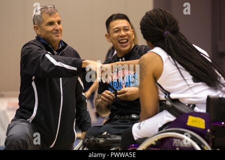 Chief Executive Officer Mike Linnington des verwundeten Krieger Projekt grüßt U.S. Army veteran Jhoonar Barrera und US-Armee SPC. Stephanie Morris nach dem Rollstuhl basketball Wettbewerb für die Abteilung 2017 der Verteidigung Krieger Spiele in Chicago, Illinois, 29. Juni 2017. Der DOD-Krieger Spiele sind eine adaptive Sport Wettbewerb für die Verwundeten, Kranken und Verletzten service Mitglieder und Veteranen. Rund 265 Athleten aus Teams aus der Armee, Marine Corps, Navy, Air Force Special Operations Command, Vereinigtes Königreich Streitkräfte, und die Australian Defence Force 30. Juni - 8. Juli in konkurrieren Stockfoto