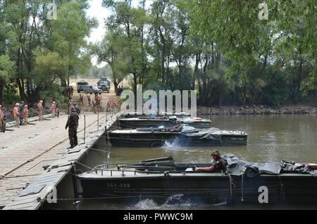 GYOR, Ungarn - EIN PMP schwimmende Brücke, die von der Feuerwehr 837th Engineer Battalion, Ohio National Guard eingesetzt, und 37th Engineer Regiment, der Ungarischen Landstreitkräfte, erstreckt sich über die Donau in einer Probe für eine taktische Bridging und River Crossing in Györ, Juli 4. Jeder Teil der Brücke wird durch zwei RPP-M 68 Schlepper geführt. Die Ausübung, Szentes Axt, ein Ungarisch-led-Übung unter Sabre Wächter, erleichtert die Freizügigkeit der 2nd Cavalry Regiment als Einheit in Rumänien für mehr Ausbildung mit den NATO-Verbündeten und Partnern bewegt. Sabre Guardian ist die größte Übung in das Schwarze Meer Re Stockfoto