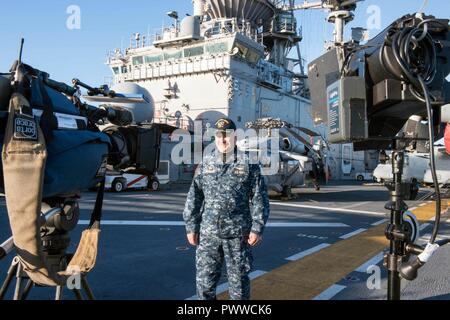 SYDNEY (1. Juli 2017) Kapitän Larry McCullen, kommandierender Offizier der Amphibisches Schiff, die USS BONHOMME RICHARD (LHD 6) spricht mit den Gastgebern 9 Nachrichten, eine australische Fernsehen morgen zeigen, aus dem Schiff Flight Deck während einer Live-Übertragung. Bonhomme Richard machte einen Port zu Sydney als Teil der Talisman SABRE 2017, der eine zweijährige USA - Australien bilaterale militärische Übung, verbindet ein Feld Training und Kommandostellenübung Interoperabilität und zur Stärkung der Grundsätze der amerikanisch-australische Bündnis zu wahren. Stockfoto