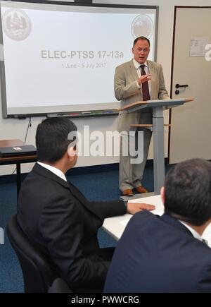 Professor James Howcroft, Course Director für das Forum Terrorismus und Sicherheit (PTSS) am George C. Marshall Europäisches Zentrum für Sicherheitsstudien, erzählt die sieben Absolventen aus sechs Ländern, dass sie nun ein Teil des PTSS Familie während der Abschlussfeier für die englische Sprache Enhancement Kurs (ELEK.) am Marshall Center Juli 5. (Marshall Center Stockfoto