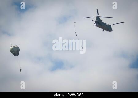 Mehrere Soldaten mit 2Nd Battalion, 505Th Parachute Regiment, 3. Brigade Combat Team Sprung von einem CH-47 Chinook Hubschrauber 3. Allgemeine Unterstützung Aviation Battalion, 82Nd airborne Combat Aviation Brigade während Operationen auf Sizilien Drop Zone in Fort Bragg, N.C., Juli 6, 2017. Stockfoto