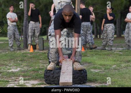 Eine Junior ROTC Cadet legt eine Planke, eine behelfsmäßige Brücke zwischen zwei Reifen während einer Übung an hurlburt Field, Fla., 26. Juni 2017 zu bilden. Mehr als 50 JROTC Kadetten aus fünf lokale High School in eine Vielzahl von Team- und Führungsqualitäten - Entwicklung von Übungen während eines Sommers Führung Klassenfahrt nach Hurlburt Field, 26. Juni - 30. Stockfoto