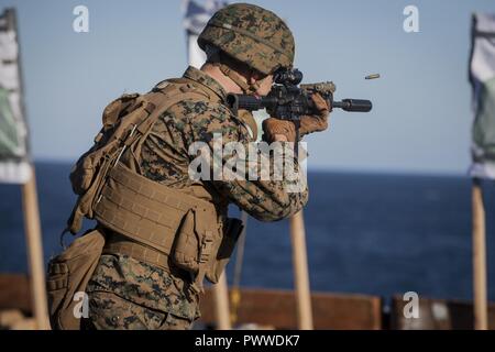 Cpl. Devan Reaves, ein Gunner mit Waffen Firma, Bataillon Landung Team, 3rd Battalion, 5th Marines, 31 Marine Expeditionary Unit, Brände eine M4A1 close-Quarters Battle Waffe mit einer KAC QD suppressor während Treffsicherheit Ausbildung an Bord der USS BONHOMME RICHARD (LHD6) während der Fahrt in den Pazifischen Ozean, 4. Juli 2017. BLT 3/5 derzeit als der Bodenkampf Element für die 31 MEU bereitgestellt wird die Erkundung state-of-the-Art Konzepte und Technologien wie die engagierte Kraft für Sea Dragon2025, eine Marine Corps Initiative für die zukünftigen Kämpfe vorzubereiten. Die 31. MEU Partner mit der Marine Stockfoto