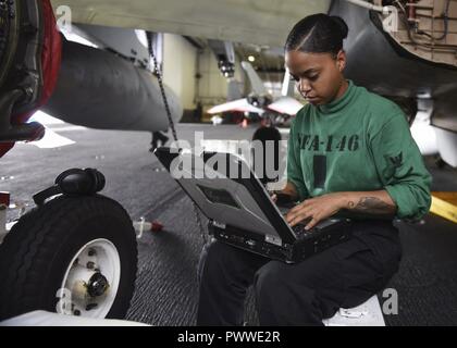 SULU SEE (4. Juli 2017) U.S. Navy's Aviation Machinist Mate 3. Klasse Alisha Tolbert, von Columbus, Ohio, einen Computer in den Hangar Bucht der Flugzeugträger USS Nimitz (CVN 68), 4. Juli 2017 verwendet, in der Sulu See. Der Nimitz ist derzeit auf Einsatz in den USA 7 Flotte Bereich der Operationen. Die US-Marine hat die Indo-Asia Pacific routinemäßig Seit mehr als 70 Jahren die Förderung von Frieden und Sicherheit in der Region patrouillierte. ( Stockfoto