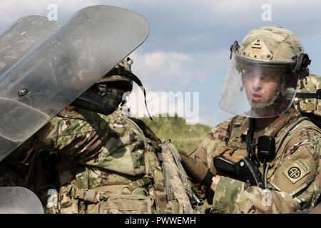 Ein fallschirmjäger von Delta Firma, 2 Battalion, 504Th Parachute Infantry Regiment, 82nd Airborne Division, Fort Bragg, N.C., hinter dem Schild in einer Menschenmenge und Riot Control training Juli 3, 2017, im JMRC in Hohenfels, Deutschland. Stockfoto