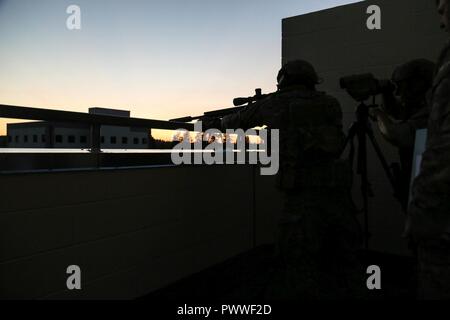 Grünhelme zu den Special Forces erweiterte Fähigkeiten Unternehmen Sniper Loslösung zugeordnet, 1 Special Forces Group (Airborne) führen durch eine urbane Stress schießen auf Joint Base Lewis-McChord, Wa., am 29. Juni, 2017. Die Ausbildung ermöglicht dem Sniper Teams auf ihre Fähigkeiten in einer stressigen und realistische städtischen schießen Umfeld zu arbeiten. Stockfoto
