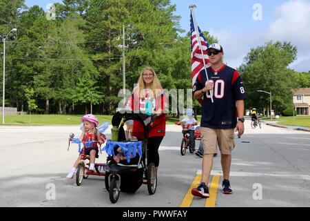 Mitglieder der Community Parade durch die Nachbarschaft in den ersten Tag der Unabhängigkeit Jugend Parade an der Marine Corps Air Station Cherry Point, N.C., 4. Juli 2017. Von Cherry Point Polizei eskortiert, die Veranstaltung für jüngere Familienmitglieder, sondern ermutigt, die größere Gemeinschaft, zusammen zu kommen. Fast 100 Cherry Point Einwohner der Gemeinde für die Festlichkeiten gesammelt. Stockfoto