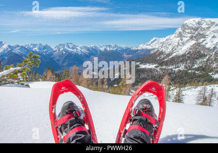 Schneeschuhwandern in den frischen Schnee der italienischen Alpen. Wintersport. Entspannen mit einem Blick, Quechua Schneeschuhen an. Stockfoto