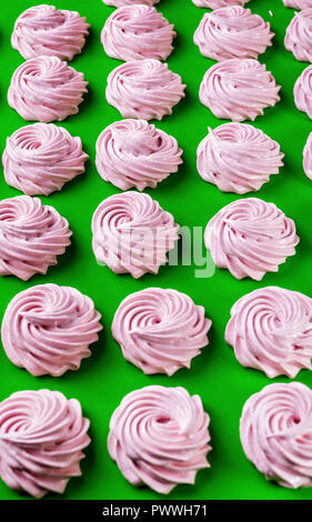 Rosa Frucht Marshmallows auf einem grünen Hintergrund. Vertikaler Dampfstoß Stockfoto