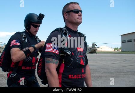 WHEELER Army Airfield - Staff Sgt. Sean O'Toole, ein Fallschirm rigger und Demonstrator für die U.S. Army Special Operations Command Parachute Demonstration Team, führt eine Prüfung der Ausrüstung auf Sgt. 1. Klasse Aaron Figel, ein Gefährte Demonstrator, hier, 4. Juli 2017. Die Mannschaft, die auch als Schwarze Dolche bekannt, sprang von einem CH-47 Chinook, von dritten Bataillon, 25 Aviation Regiment, 25 Combat Aviation Brigade, 25 Infanterie Division, und Fallschirm in Weyand Feld am Schofield Kasernen für den 4. Juli spektakulär. Stockfoto