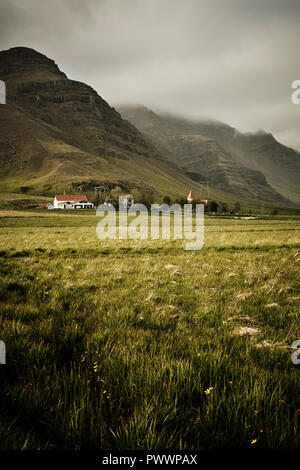 Ein Bauernhaus und der Kirche in der fernen Berge und Landschaft von South East Island. Stockfoto