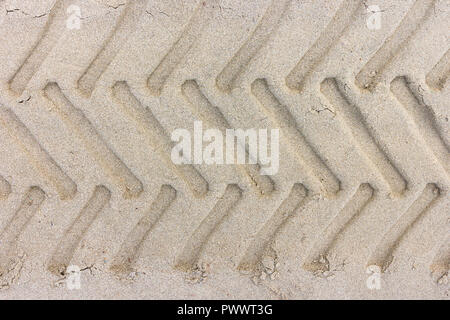 Reifenprofil Fußabdrücke eines Traktors auf dem Sand Strand, Sand Textur für Hintergrund. Stockfoto