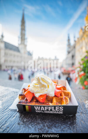 Traditionelle belgische Waffeln mit Erdbeeren und Sahne in der Nähe des Grand Place, blur Hintergrund Stockfoto