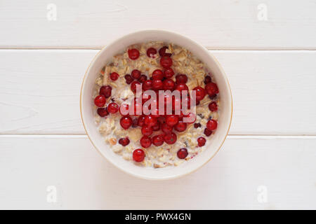 Ansicht von oben Frühstück Schüssel Müsli mit frischen Johannisbeeren Beeren auf weiße Holztisch Stockfoto