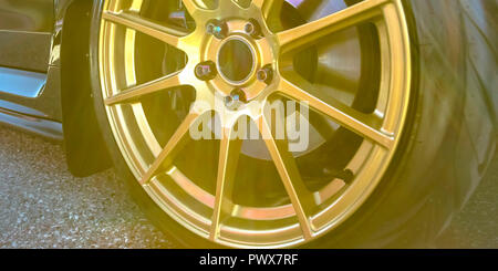 Reifen Felge mit Bremsscheibe zwischen Gold Speichen gesehen Stockfoto