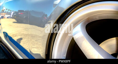 Felge eines glänzenden weißen Auto mit blauen Aufkleber Stockfoto