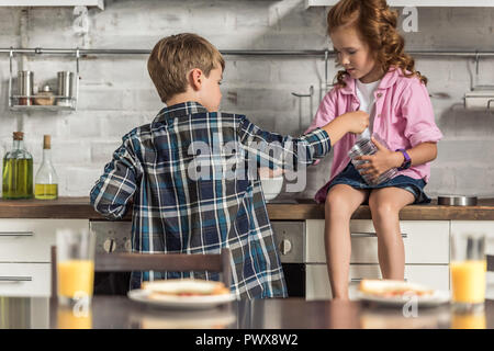 Kleiner Bruder und Schwester kochen gemeinsames Frühstück am Morgen Stockfoto