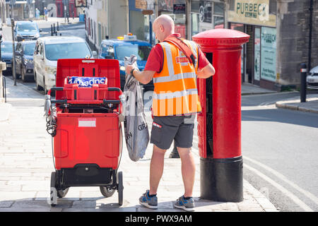 Royal Mail Postbote beim Entleeren eines Post Box, High Street, Swanage, Isle of Purbeck, Dorset, England, Vereinigtes Königreich Stockfoto