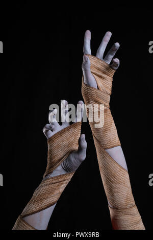 Mumie Stretching bis Hände gewickelt in Bandagen, Halloween Theme Stockfoto
