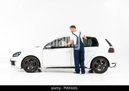 Rückansicht der Automechaniker Reinigung Auto Fenster nach der Reparatur auf Weiß Stockfoto