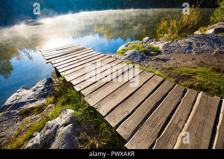 Holzterrasse auf der felsigen Ufer in den frühen misty morning Stockfoto