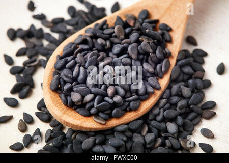 Nahaufnahme von schwarzem Sesam in Löffel aus Holz Stockfoto