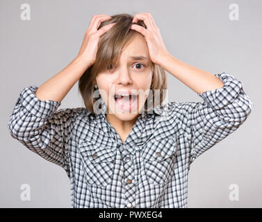 Close-up emotionale Portrait von aufgeregten kleinen Mädchen. Lustig nett überrascht, Kind 10 Jahre alt mit der Mund vor Staunen offen. Schockiert, Teenager, auf grau Bac Stockfoto