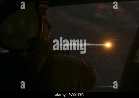 MOUNT BUNDEY TRAINING AREA, Australien - US Marine Cpl. Jakob Elifrits, door gunner, Marine Light Attack Helicopter Squadron 367, Marine Drehkraft Darwin, Uhren als Flares von Ein UH-1Y Venom Entlastung nach Abschluss einer Antenne gun Angebot am Berg Bundey Training Area, 21. Juni 2017. Während der Ausbildung, Piloten und Besatzungsmitglieder genau engagierte Ziele mit geführten Raketen, M2 .50 Kaliber Maschinenpistole und M240B Medium Maschinengewehr aus einer UH-1Venom. Elifrits ist von Prairie Village, Kansas. Stockfoto