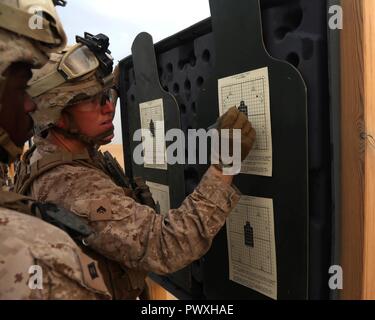 Us Marine Corps Cpl. Charles Brown, einem truppführer, erklärt ein Schuß Gruppe U.S. Navy Seaman Christophe Waschen, ein Corpsman, sowohl mit 1St Battalion, 7th Marine Regiment, Special Purpose Marine Air-Ground Task Force-Crisis Response-Central Befehl, während einer Schlacht Anblick Nullbereich im Nahen Osten, 5. Juli 2017. Die Ausbildung überprüft die Genauigkeit der Anblick für die Ausrichtung der Waffe und sorgt für SPMAGTF Marines bereit sind zu reagieren und zu einer Vielzahl von Szenarien, die nicht über den Bereich des USCENTCOM spielen reagieren. SPMAGTF-CR-CC ist ein sich selbst tragender Expeditionary unit, prov Stockfoto