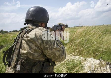 Eine ukrainische Soldaten bis zum yavoriv Combat Training Center Gegenkraft Unit engagiert sich nähert sich Soldaten aus 1. der ukrainischen Armee Airmobile Bataillon, 79 Air Assault Brigade während ein Bataillon Kraft - Kraft der Übung, die als Schlußstein des Bataillon während der Ausbildung an der Yavoriv CTC auf der internationalen Friedens und der Sicherheit, in der Nähe der Yavoriv, der Ukraine, der am 29. Juni. Stockfoto