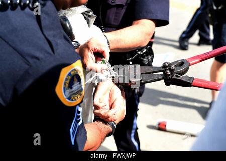 Des Moines Polizisten brechen Sie Ketten ist ein Demonstrant und ersetzen Sie sie mit Handschellen am 28. Juni 2017, an der 132 D-Flügel in Des Moines, Iowa. Die Demonstranten mehrere Gebühren konfrontiert. Stockfoto